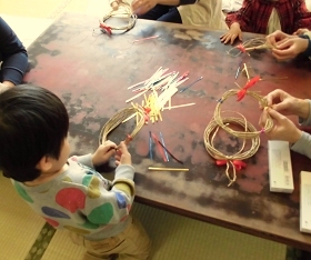 大江分館　冬のおはなし会スペシャルでクリスマスリースを作っている子どもの写真