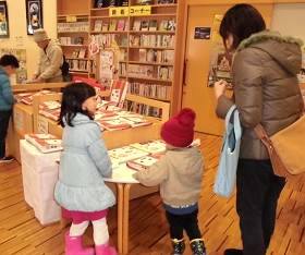 夜久野分館で「本の福袋」を選ぶ親子の写真